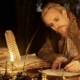 Shakespeare at his desk by night, writing with a quill by candle light