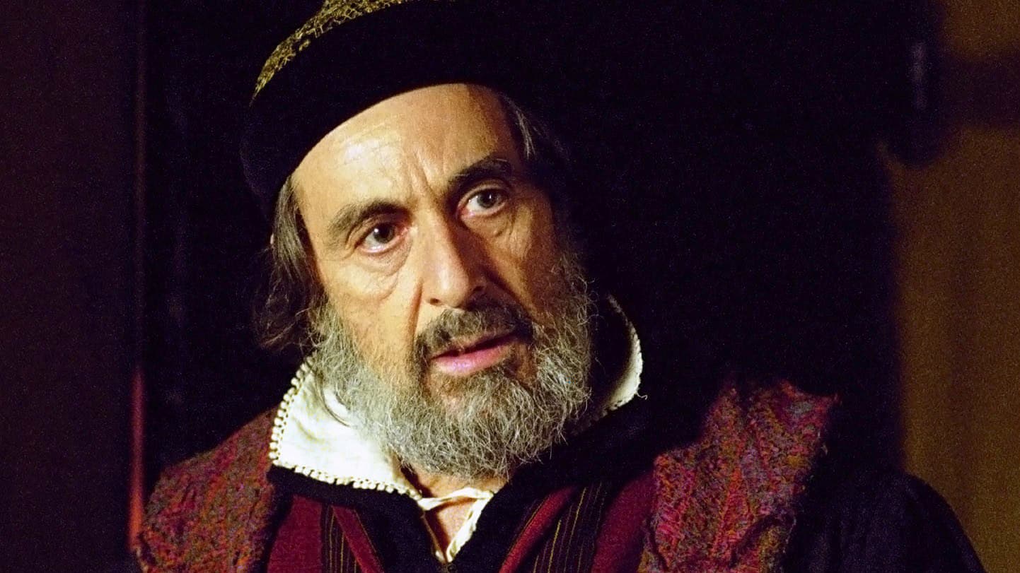 al pacino dressed in flowing red robe with black headband, playing Shylock in The Merchant of Venice