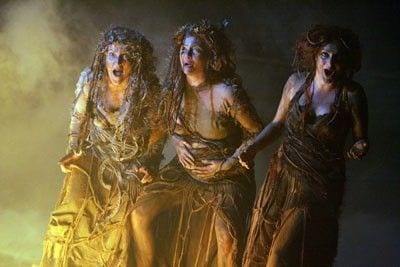 Three witches stnading with deranged lokoing faces