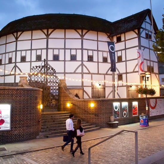 Exterior shot of Shakespeare's Globe Theatre today, with couple walking in front